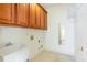 Functional laundry room with sink, ample cabinets, utility connections, and a view of a sunlit room at 2322 Norbury Se Cv, Smyrna, GA 30080
