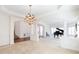Spacious living room with grand piano, columns, chandelier and neutral carpet, perfect for entertaining at 2322 Norbury Se Cv, Smyrna, GA 30080