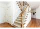 Carpeted staircase with white railings and wood accents, leading to the upper level with hardwood flooring at 2322 Norbury Se Cv, Smyrna, GA 30080