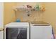 Functional laundry room with modern front load washer and dryer and overhead storage at 3739 Newhalem Sw St, Atlanta, GA 30331
