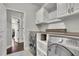 This is a laundry room with front loading washer and dryer and built in shelving at 4681 Gablestone Dr, Hoschton, GA 30548