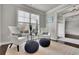 Sitting room with large window and two chairs and ottomans with accent pillows at 4681 Gablestone Dr, Hoschton, GA 30548