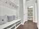 Mudroom with a white bench, storage baskets, and a walk-in pantry stocked with storage containers at 4681 Gablestone Dr, Hoschton, GA 30548
