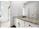 Bathroom vanity with granite countertop, white cabinets, a large mirror, and dark hardware at 5655 Cross Gate Dr, Atlanta, GA 30327