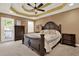 Spacious bedroom with a decorative ceiling, ceiling fan, and stylish, dark wood furniture at 1074 Fieldstone Dr, Canton, GA 30114