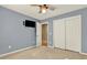 Bedroom features light grey walls, a ceiling fan, a closet, and a mounted television at 1074 Fieldstone Dr, Canton, GA 30114