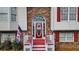 Inviting front entrance with a red door, arched window, white railings, and brick accents creates a warm welcome at 1074 Fieldstone Dr, Canton, GA 30114