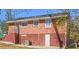 Back exterior showcasing brick, access to the basement, and windows to the upper levels at 2413 Hillside Ave, Decatur, GA 30032
