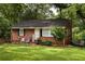 Charming brick home with a well-manicured lawn, cozy front porch and mature trees at 2413 Hillside Ave, Decatur, GA 30032
