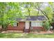 Charming brick home featuring a cozy front yard with mature trees and landscaping at 2413 Hillside Ave, Decatur, GA 30032