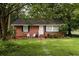 Quaint brick home with a lush green lawn, mature trees, and inviting front entrance at 2413 Hillside Ave, Decatur, GA 30032