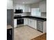 Modern kitchen with stainless steel appliances, black granite counters, and white cabinets at 2413 Hillside Ave, Decatur, GA 30032
