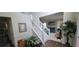 Bright foyer with a staircase, hardwood floors, and an open view into a living room area with a couch and art on the wall at 2453 Wall Se St, Conyers, GA 30013