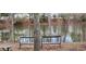 Backyard view of a peaceful pond surrounded by trees and featuring a picnic table and seating for relaxing outdoors at 2453 Wall Se St, Conyers, GA 30013