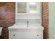 Bathroom features brick accent wall with a vintage vanity with white sink at 2826 Summit Ridge Dr, Marietta, GA 30066