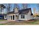 Charming home exterior featuring white siding, a dark roof, and an enclosed sunroom at 285 Belmont Trl, Covington, GA 30016