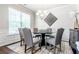 Bright dining room with a modern round table, chandelier, and large window at 113 Maplewood Ln, Conyers, GA 30094