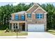 Two story home with brick exterior, two-car garage, shuttered windows and landscaped front yard at 113 Maplewood Ln, Conyers, GA 30094