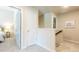 Upstairs hallway with neutral walls, carpet floors, white doors, white banister, and access to bedrooms at 113 Maplewood Ln, Conyers, GA 30094