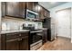 Gourmet kitchen featuring stainless steel appliances, dark cabinetry, granite countertops, and tile backsplash at 113 Maplewood Ln, Conyers, GA 30094