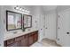 Bathroom featuring double vanity with dark cabinets, decorative mirrors and light fixtures at 1217 Trophy Club Ave, Dacula, GA 30019