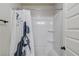 White bathroom features a tub, shower, and shelving for storage at 1217 Trophy Club Ave, Dacula, GA 30019
