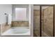 Bathroom featuring a soaking tub and enclosed shower with tile surround at 1217 Trophy Club Ave, Dacula, GA 30019