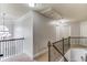 Upstairs hallway with iron railing, high ceilings, and a decorative chandelier at 1217 Trophy Club Ave, Dacula, GA 30019
