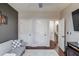 Sitting room featuring a gray futon and decor, as well as multiple doors to other rooms at 1217 Trophy Club Ave, Dacula, GA 30019