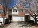 Charming brick townhouse featuring a two-car garage and flowering trees in the front yard at 4620 Grand Central Pkwy, Decatur, GA 30035