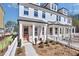 Charming new townhome featuring a brick facade, covered porch, and quaint white picket fence at 224 Village Overlook # K3, Canton, GA 30114