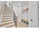 Modern staircase with wood treads, a dark metal railing, and a built-in bench with storage cubbies at 224 Village Overlook # K3, Canton, GA 30114