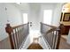 A view down a staircase with wood treads, iron spindles, and carpet on the second floor hallway at 5750 Palmtree Pass, Cumming, GA 30040