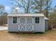 Outdoor storage shed featuring double doors and windows to compliment the residential property at 583 Mount Zion Rd, Oxford, GA 30054