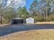 View of the asphalt driveway and two storage sheds in the backyard of the property at 583 Mount Zion Rd, Oxford, GA 30054