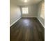This bedroom features dark laminate flooring and natural light from two windows at 814 Humphries Sw St, Atlanta, GA 30310