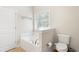 Bathroom featuring a white soaking tub, toilet and window at 106 Saint Margrit Cir, Stockbridge, GA 30281
