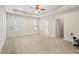 Large bedroom with tray ceilings, neutral carpet, windows, and a ceiling fan at 106 Saint Margrit Cir, Stockbridge, GA 30281