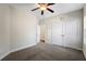 Neutral bedroom featuring a ceiling fan, wall clock, carpet, and closet at 106 Saint Margrit Cir, Stockbridge, GA 30281