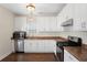 Well-lit kitchen featuring white cabinetry, stainless steel appliances, and hardwood floors at 106 Saint Margrit Cir, Stockbridge, GA 30281