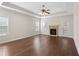 Bright living room with a ceiling fan, hardwood floors, a fireplace, and large windows at 106 Saint Margrit Cir, Stockbridge, GA 30281
