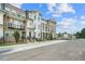 Street view of new townhomes featuring brick and siding, balconies, and well-maintained lawns at 2380 Elgar Park Pl # 101, Duluth, GA 30096