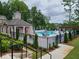 Community pool area with a modern clubhouse, metal fencing and manicured landscaping at 2380 Edgar Park Pl # 101, Duluth, GA 30096