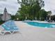 Community pool area with resort-style lounge chairs and a pergola for shade at 2380 Edgar Park Pl # 101, Duluth, GA 30096