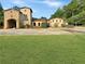Stunning Tuscan-style home with stone accents, arched entryway, and a lush green lawn at 3382 Milan Ct, Douglasville, GA 30135