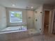 Luxurious bathroom featuring a soaking tub, glass-enclosed shower, and modern finishes at 3687 Thornhill Ct, Douglasville, GA 30135