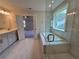 Elegant bathroom featuring a soaking tub, glass shower, dual vanity, and marble floors at 3687 Thornhill Ct, Douglasville, GA 30135