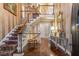 Elegant foyer featuring a chandelier, hardwood floors, staircase and decorative wallpaper at 8185 Habersham Waters Rd, Atlanta, GA 30350