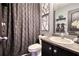 Bathroom featuring a dark vanity, framed mirror, and decorative shower curtain at 120 Sunflower Ln, Covington, GA 30016