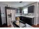 Modern kitchen featuring sleek black cabinetry, stainless steel appliances, and an island with a black countertop at 120 Sunflower Ln, Covington, GA 30016